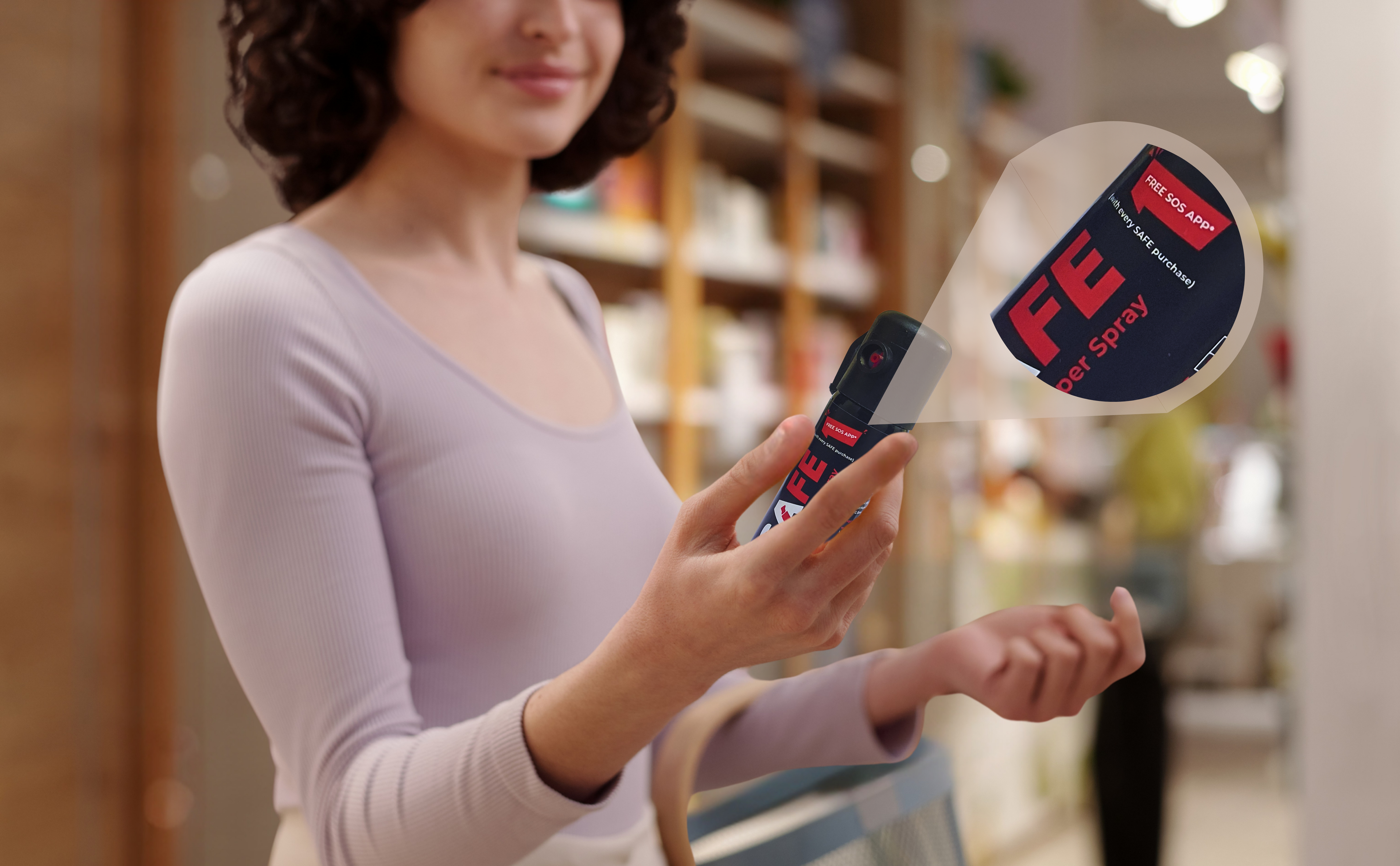 Woman holding self-defense pepper spray product with 'SAFE' branding in   shopping mall.